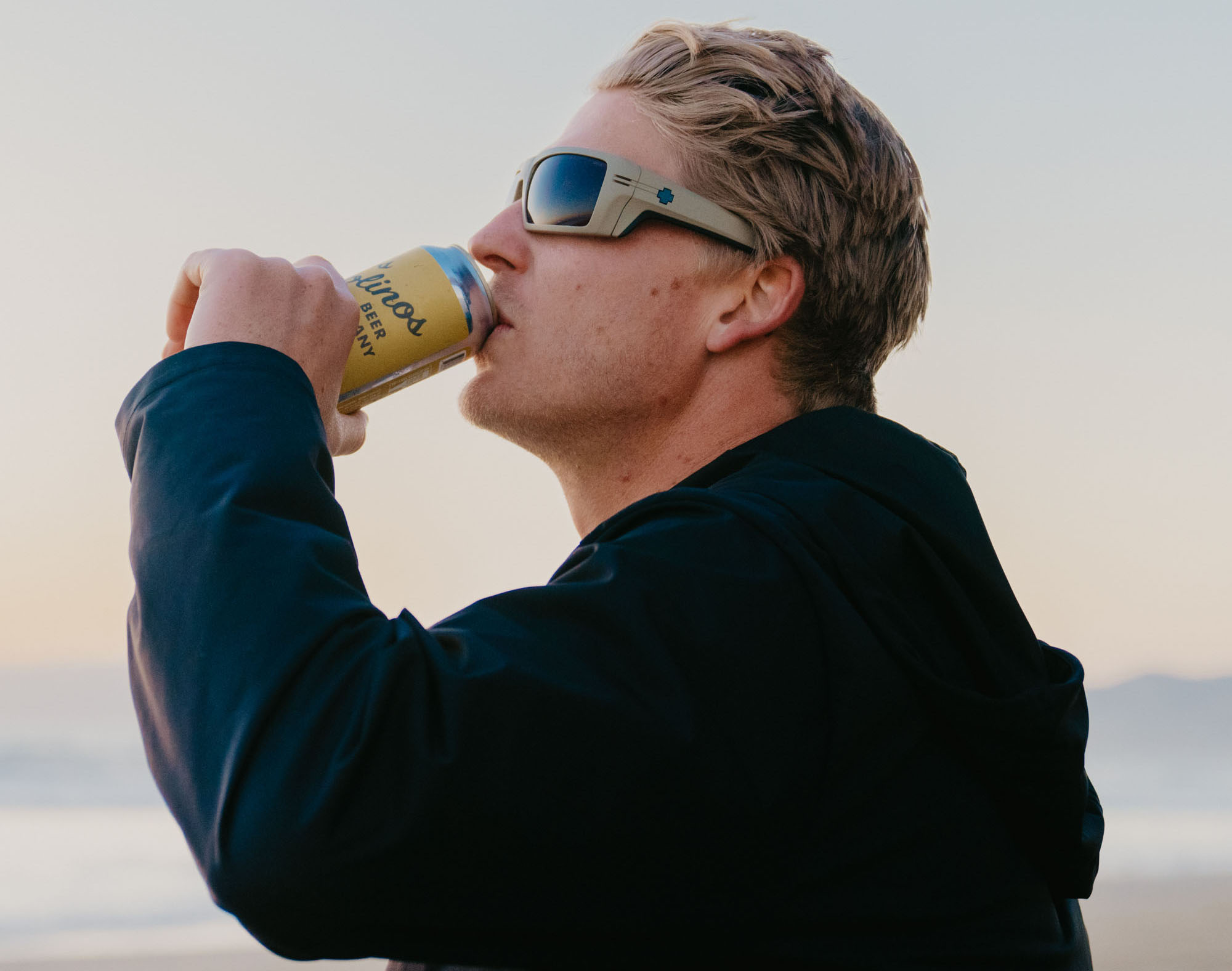 Model wearing Rebar Sunglasses drinking a beer