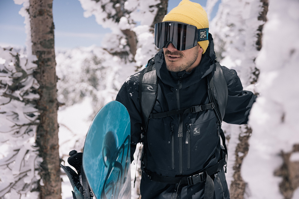 Chris Rasman wearing snowboard goggles and snowboarding